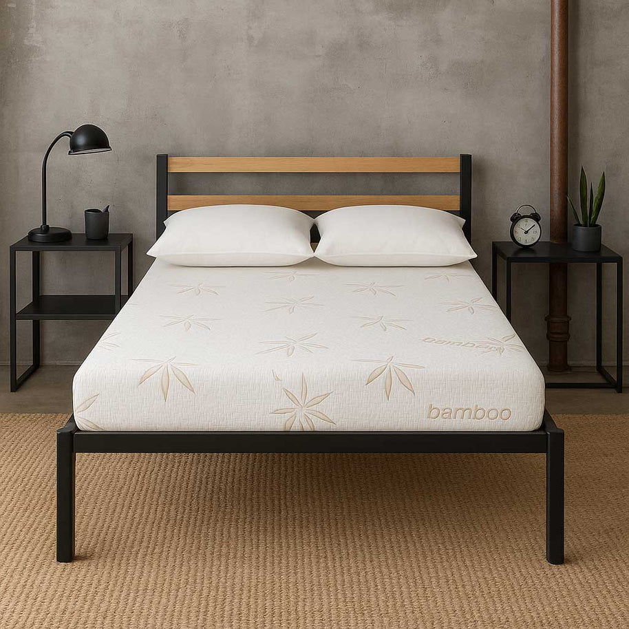 Latex Bed with white mattress featuring bamboo branding, wooden headboard, and nightstands with decor items.